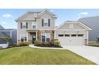 Charming two-story home features a combination of stone and siding with an attached two car garage at 14116 Glaswick Dr, Charlotte, NC 28278