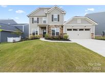 Charming two-story home featuring stone accents, a well-manicured lawn, and attached two car garage at 14116 Glaswick Dr, Charlotte, NC 28278