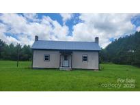 Charming single story home on a large lot with a metal roof and chimneys on either side at 1672 Riverview Rd, Lincolnton, NC 28092