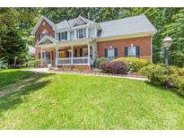 Charming two-story brick home with a welcoming front porch and well-manicured lawn at 171 Highland Woods Ct, Denver, NC 28037