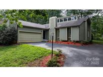 Inviting exterior of a two-story home featuring an attached garage, chimney, and well-maintained landscaping at 1748 4Th Street Ne Ct, Hickory, NC 28601