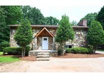 Charming stone home featuring a covered front porch and manicured landscaping at 1810 Highway 55 W Hwy, Clover, SC 29710