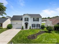 Charming two-story home with a well-manicured lawn, garden, and attached two-car garage at 1901 Summit Ridge Ln, Kannapolis, NC 28083
