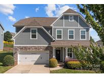 Charming two-story home boasts stone accents, a manicured lawn, and a welcoming entrance at 205 Church St, McAdenville, NC 28101