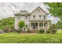 Charming two-story home with inviting front porch and manicured landscaping at 2100 Darian Way, Waxhaw, NC 28173