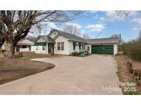 Charming home features a well-maintained exterior with a spacious driveway and a green garage door at 3220 Harmony Hwy, Harmony, NC 28634