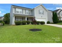 Charming two-story home featuring a well-manicured lawn and lush landscaping at 3933 Cameron Creek Dr, Matthews, NC 28105