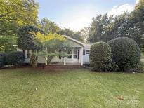 Charming single-story home with a well-maintained lawn and mature trees in a serene neighborhood at 400 Archibald Rd, Concord, NC 28025