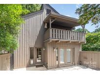 Side exterior of the property showcasing a balcony, a small patio, and doors leading inside the house at 4725 Rounding Run Rd, Charlotte, NC 28277