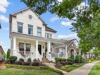 Charming two-story white brick home with a welcoming front porch and well-manicured landscaping at 7732 Waverly Walk Ave, Charlotte, NC 28277