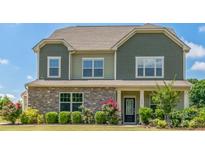 Charming two-story home features stone accents, a covered porch, and well-maintained landscaping at 1012 Leland Dr, Wesley Chapel, NC 28104