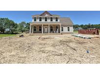 Two-story home with brick facade, white columns, complementary siding, and a covered front porch at 11543 Valley Oak Ln, Stanfield, NC 28163