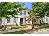 Charming two-story home with white siding, black door, manicured lawn and landscaping at 12342 Carrigan Ct, Huntersville, NC 28078