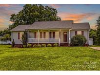Charming single-story home features a welcoming front porch and a well-manicured lawn at 189 Lochshire Ln, Woodleaf, NC 27054