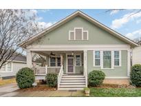Charming green home with a inviting front porch and well-maintained landscaping at 232 Orange St, Charlotte, NC 28205