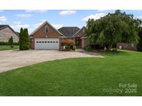 Charming brick home with a well-manicured lawn and attached two-car garage at 2872 Wheat Field Ct, Lincolnton, NC 28092