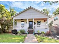Charming home featuring a cozy front porch with ceiling fan and a beautifully landscaped yard at 323 Keswick Ave, Charlotte, NC 28206