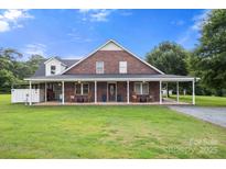 Charming brick home with a spacious front porch, perfect for enjoying the outdoors at 3451 Greene Rd, Monroe, NC 28110