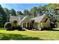 Charming single-Gathering home with manicured lawn, lush landscaping, and inviting covered entryway at 347 Bayberry Creek Cir, Mooresville, NC 28117