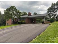 Cozy brick home with a covered carport, front porch, and long driveway on a spacious, grassy lot at 356 Lucky Hollow Rd, Hickory, NC 28601