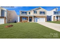 Charming two-story home featuring stone accents, a manicured lawn, and a welcoming front porch at 6708 Barcelona Way, Charlotte, NC 28214