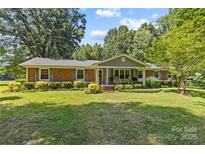 Charming brick home with a well-manicured lawn and beautiful landscaping at 8101 Truelight Church Rd, Mint Hill, NC 28227