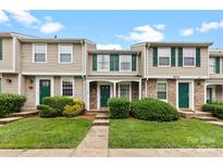 Charming townhome featuring green shutters, a manicured lawn, and inviting front entrances at 9606 Vinca Cir # E, Charlotte, NC 28213