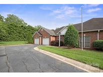 Brick home featuring an attached two car garage with a beautifully manicured lawn and driveway at 104 Mooreland Ne Dr, Conover, NC 28613