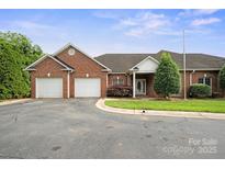 Charming brick home with attached two-car garage, manicured lawn, and inviting entryway at 104 Mooreland Ne Dr, Conover, NC 28613
