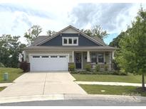 Charming single-story home featuring a front porch, two-car garage, and well-maintained landscaping at 10417 Bluejack Oak Ct, Huntersville, NC 28078