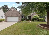 Charming brick home with well-manicured lawn and mature landscaping, creating excellent curb appeal at 1119 Williamstown Rd, Matthews, NC 28105