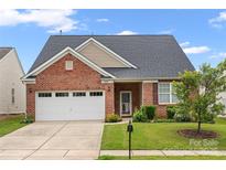 Charming brick home with a well-maintained lawn, two-car garage, and inviting front porch at 11608 Downy Birch Rd, Charlotte, NC 28227
