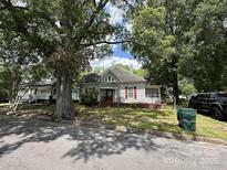 Charming home featuring a red door and shutters, complemented by mature trees in a yard at 118 Hemphill Ave, Chester, SC 29706