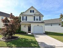 Charming two-story home with a well-maintained lawn, driveway, and attached garage, situated under a bright, clear sky at 12131 Honor Guard Ave, Charlotte, NC 28277