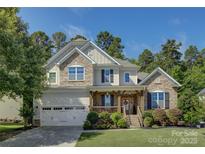 Charming two-story home with stone accents, inviting porch, and manicured landscaping on a sunny day at 17537 Caddy Ct, Charlotte, NC 28278