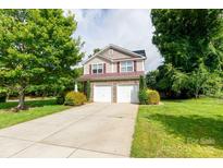 Charming two-story home features a stone facade, two-car garage, and well-manicured landscaping at 405 Jenny Skip Ln, Rock Hill, SC 29732