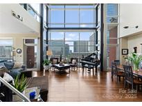 Bright living room with piano and stunning city view at 435 S Tryon St # 907, Charlotte, NC 28202
