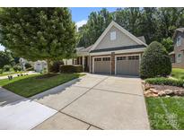 Charming home featuring a well-manicured lawn, mature trees, and a two-car garage, enhancing its curb appeal at 4527 Hubbard Falls Dr, Charlotte, NC 28269