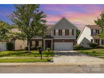 Charming two-story home with brick accents, a well-manicured lawn, and a two-car garage at 5307 Ayers Orchard Way, Charlotte, NC 28227