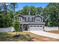 Charming two-story home with gray siding, a well-manicured lawn, and an attached two-car garage at 6425 Pamela St, Huntersville, NC 28078