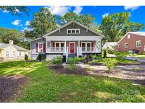 Charming home featuring red shutters, a cozy front porch, and lovely landscaping at 716 W Graham St, Shelby, NC 28150