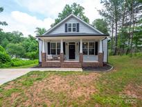 Charming home featuring a brick-lined front porch and beautifully maintained landscaping at 720 4Th St, Stanley, NC 28164