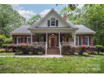 Charming brick home with a welcoming front porch and manicured landscaping, enhancing its curb appeal at 7408 Mockingbird Ln, Waxhaw, NC 28173
