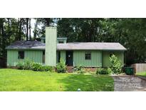 Charming single-story home with unique exterior paint and a well-manicured front lawn at 7705 Stone Canyon Ln, Charlotte, NC 28227