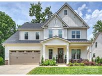 Beautiful two story home with a well manicured lawn, two-car garage, and inviting front porch at 822 River Oaks Ln, Charlotte, NC 28226
