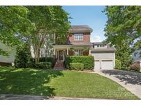 Charming brick and siding home with a well-manicured lawn, mature trees, and a two-car garage at 10121 Edgecliff Rd, Huntersville, NC 28078