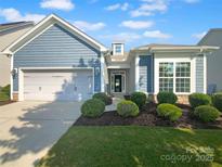 Charming home featuring manicured landscaping, a two-car garage and blue siding at 13419 Morgan Lee Ave, Charlotte, NC 28213