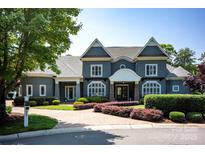Stately gray two-story home showcasing beautiful landscaping and a stone driveway leading up to the inviting front entrance at 175 Rehoboth Ln, Mooresville, NC 28117