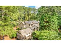 An elegant home with a metal roof surrounded by lush green trees and landscaped lawns at 177 Yadkin Falls Rd, New London, NC 28127