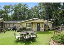An eye-level shot showcases the back of the home with an outdoor dining set on an artificial lawn at 4412 Dobys Bridge Rd, Fort Mill, SC 29707